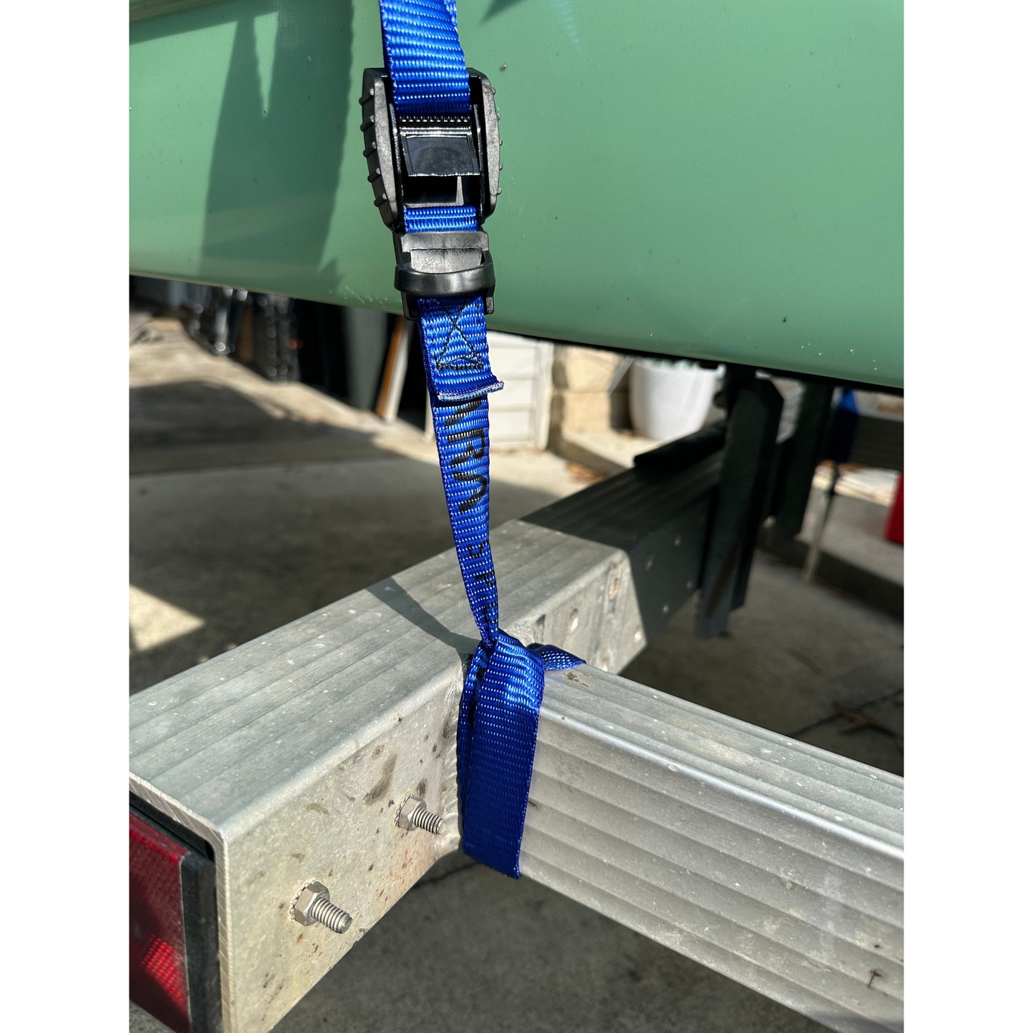 Blue strap tied to a metal post with a green container in the background